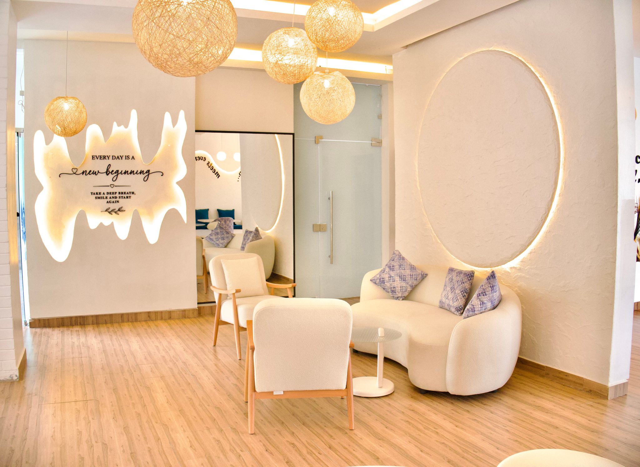 Café Naimora reading nook with curved sofa, globe pendant lights and the new beginning wall